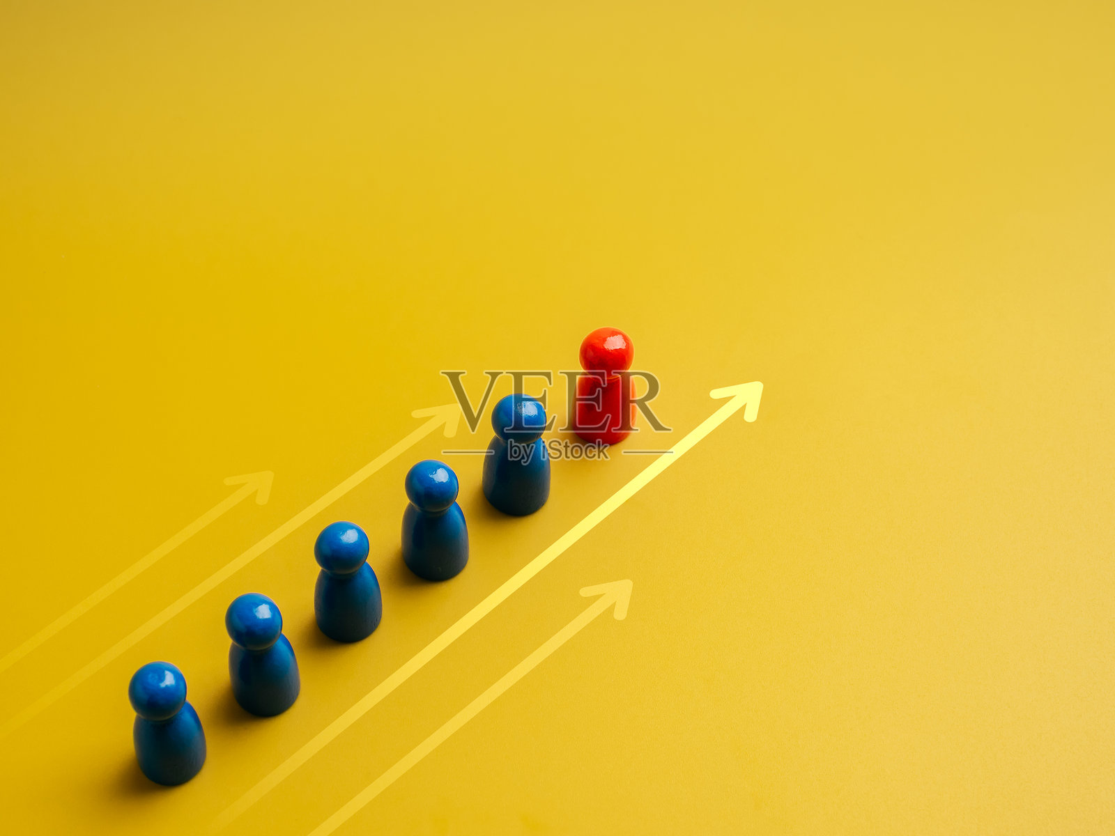 红色的不同者，领导者，带领白色木偶娃娃团队，团队象征，背景为黄色的向前移动箭头。领导力，经理，独特，影响者，人才，团队合作概念。照片摄影图片