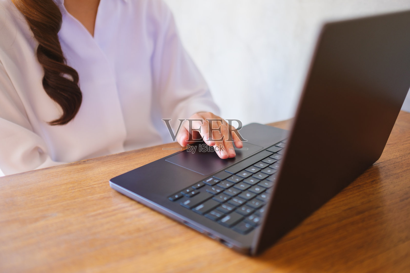 特写镜头：一位女性在使用笔记本电脑触控板工作照片摄影图片