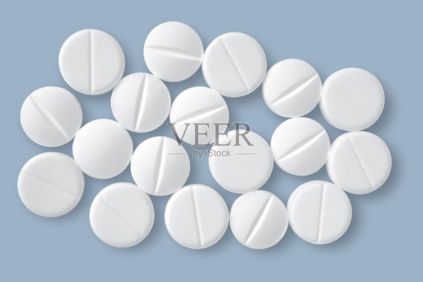 蓝色背景上的白色圆形药片。照片摄影图片