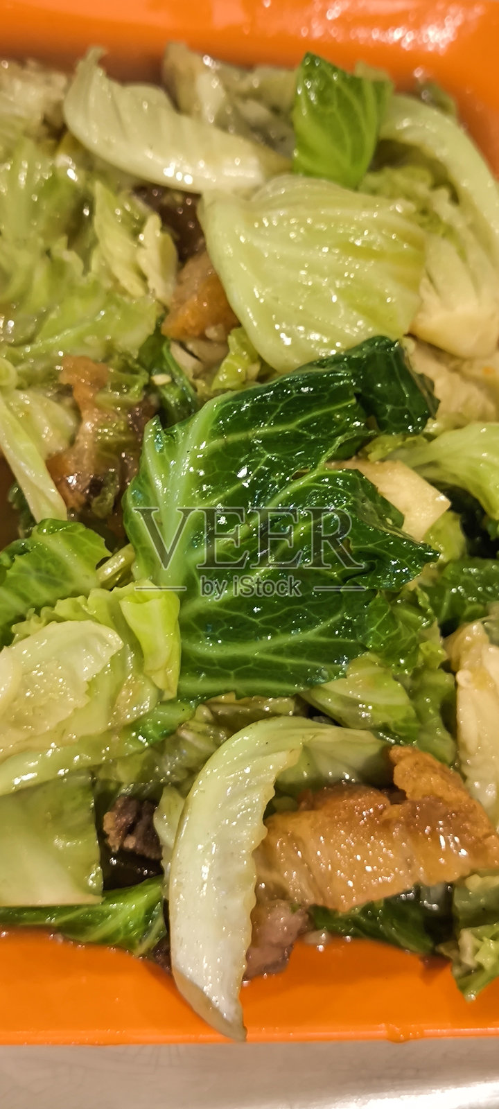 橙色盘子上的炒空心菜和脆皮猪肉照片摄影图片