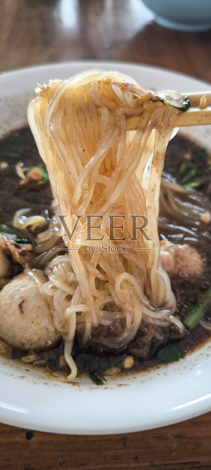 桌子上的碗里盛着面条照片摄影图片