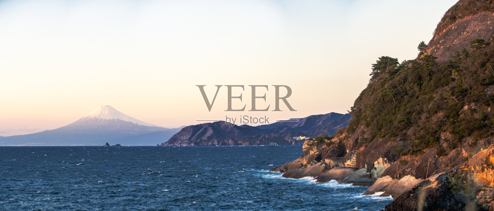 从日本伊豆半岛的久能海岸俯瞰富士山的壮丽日落景色照片摄影图片