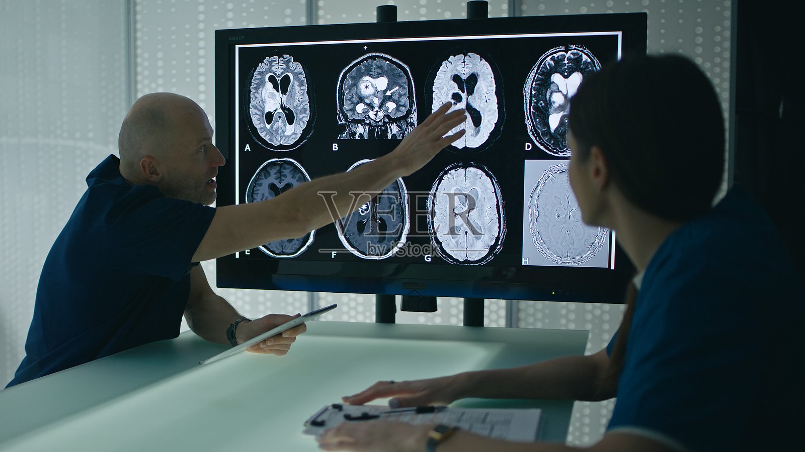医生或科学家与同事讨论脑电图结果，指出需要进一步调查的部分照片摄影图片