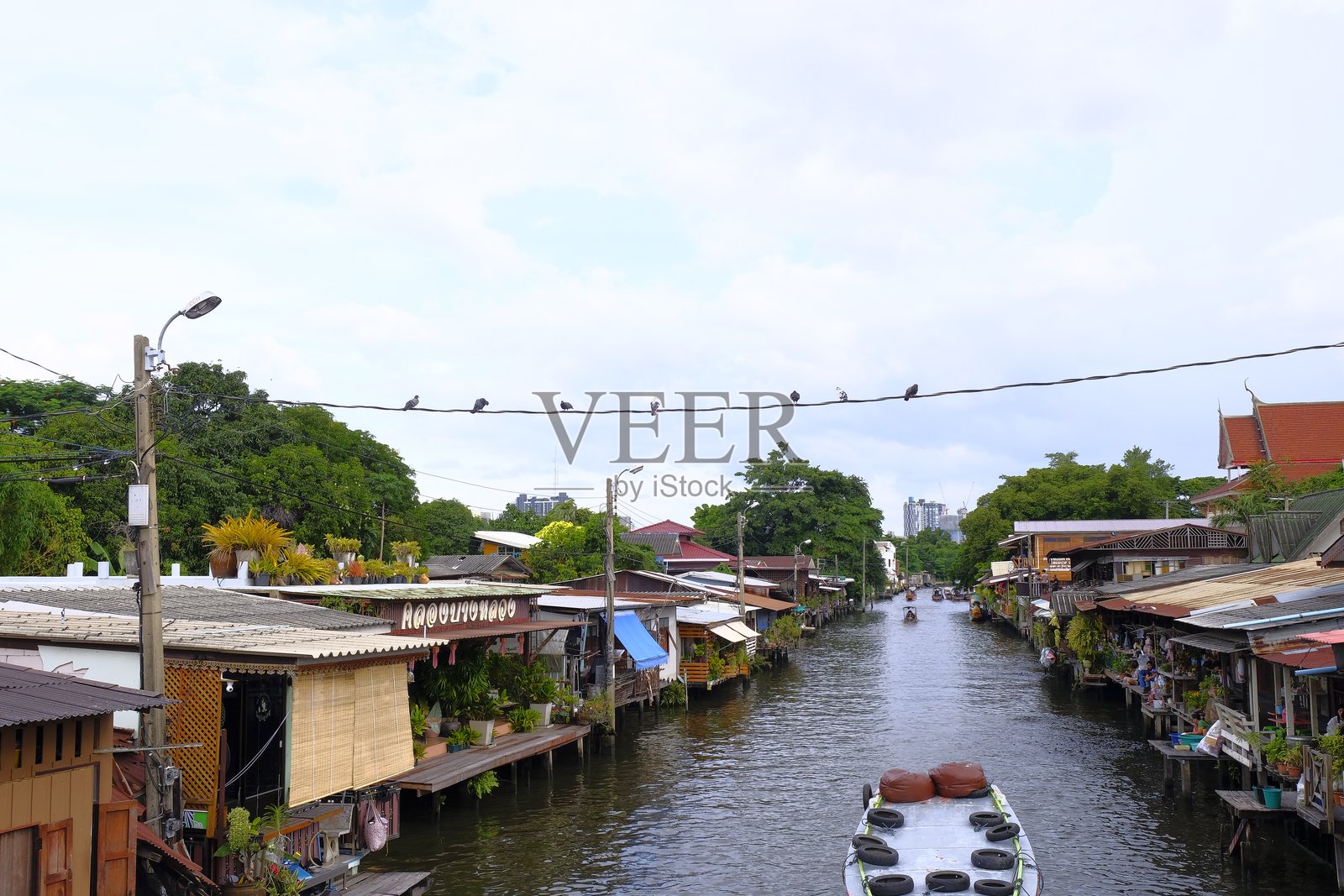 邦朗运河 – 传统社区生活、锡屋顶房屋、长尾船和河边商店照片摄影图片