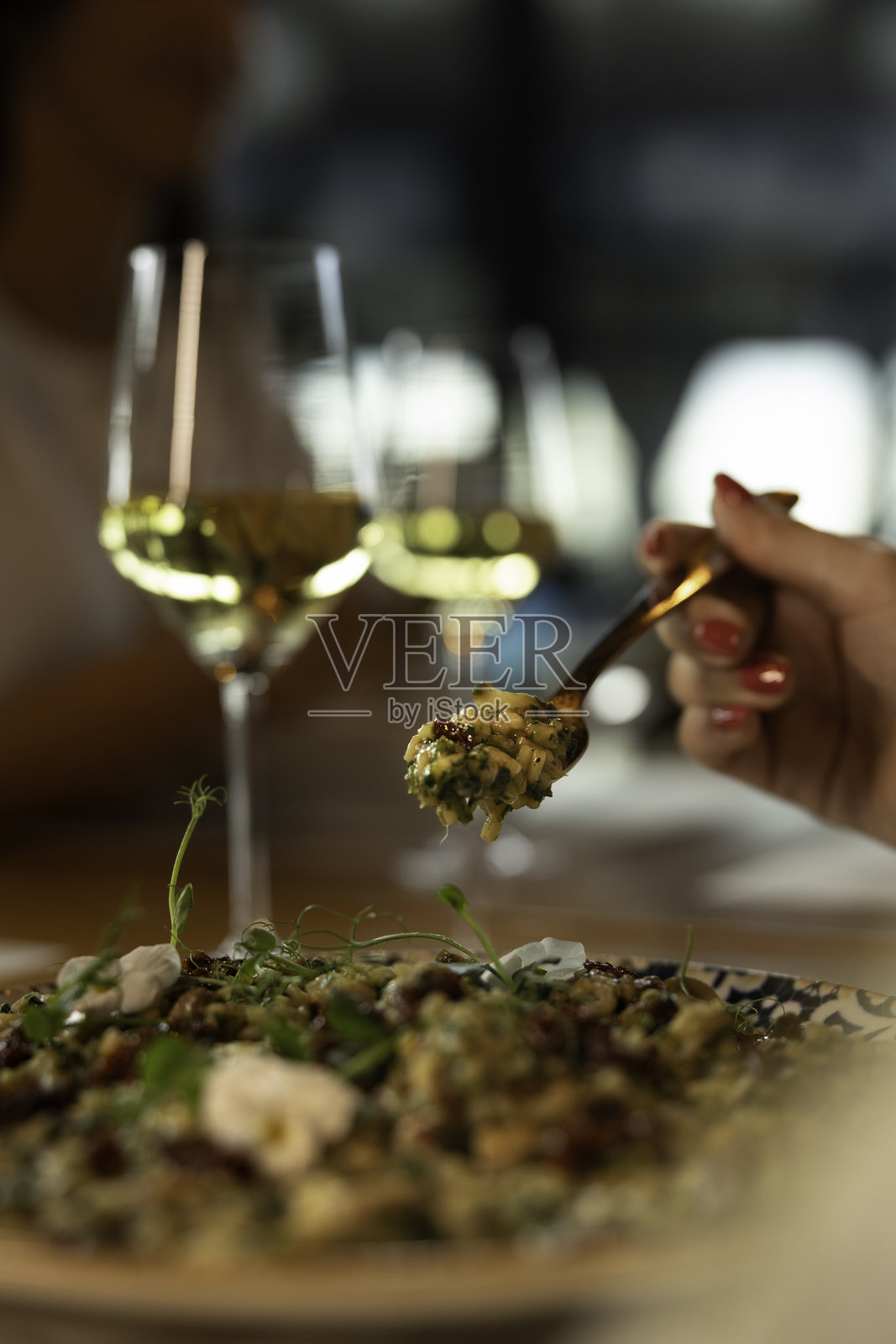 餐叉与意大利调味饭，背景中有酒杯照片摄影图片