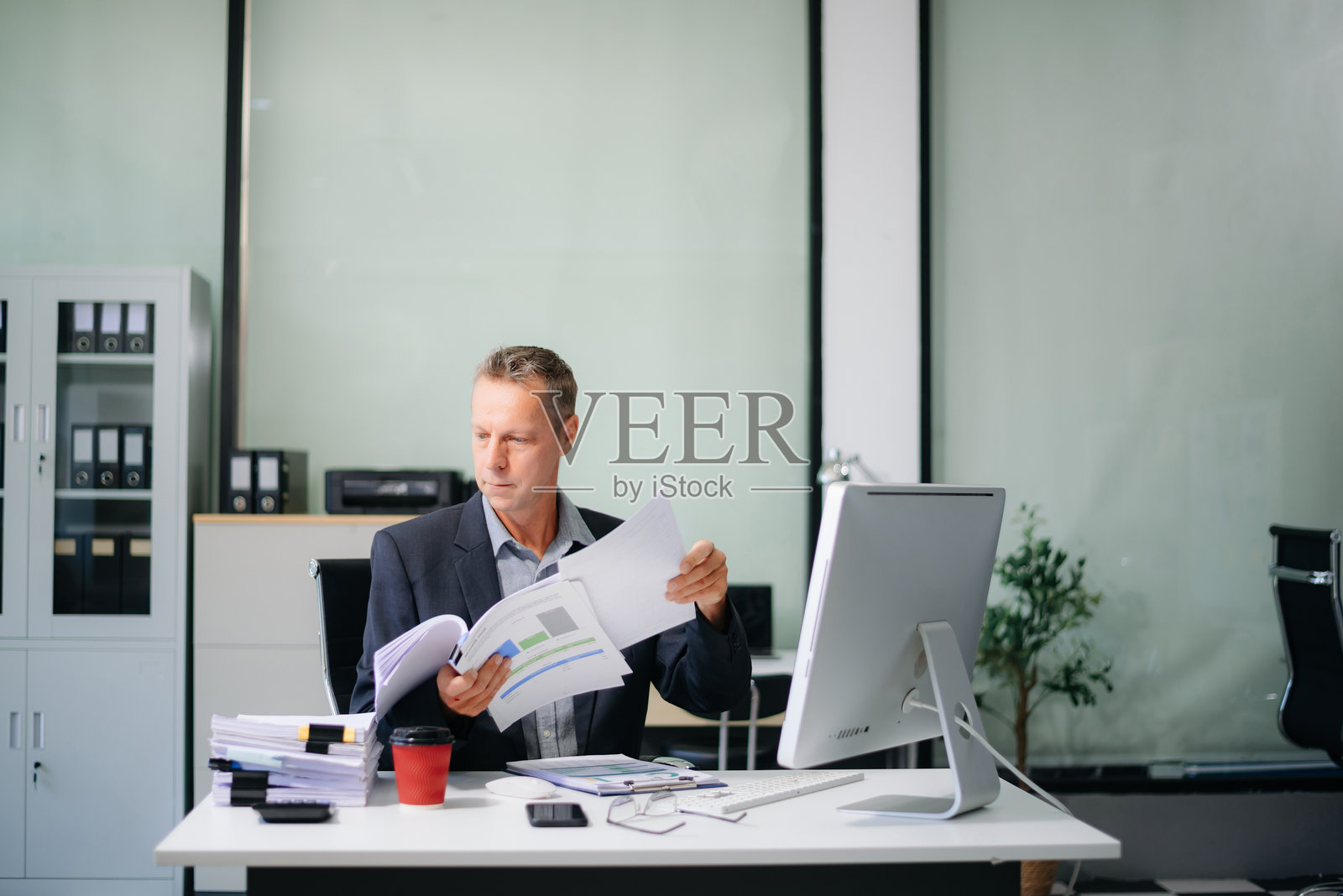 成熟的商务人士高管经理正在看着笔记本电脑，观看在线网络研讨会培训或进行虚拟会议照片摄影图片