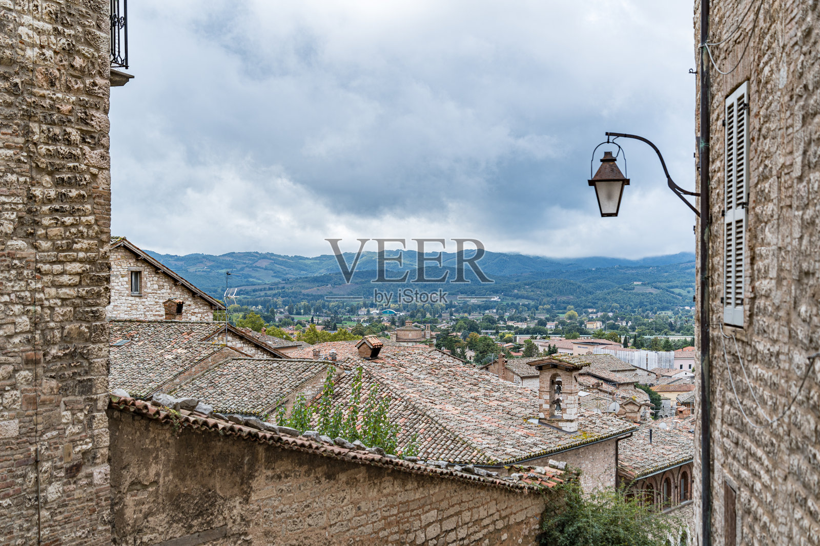 意大利翁布里亚州古比奥的一条街道，路灯和一栋带窗户的建筑照片摄影图片