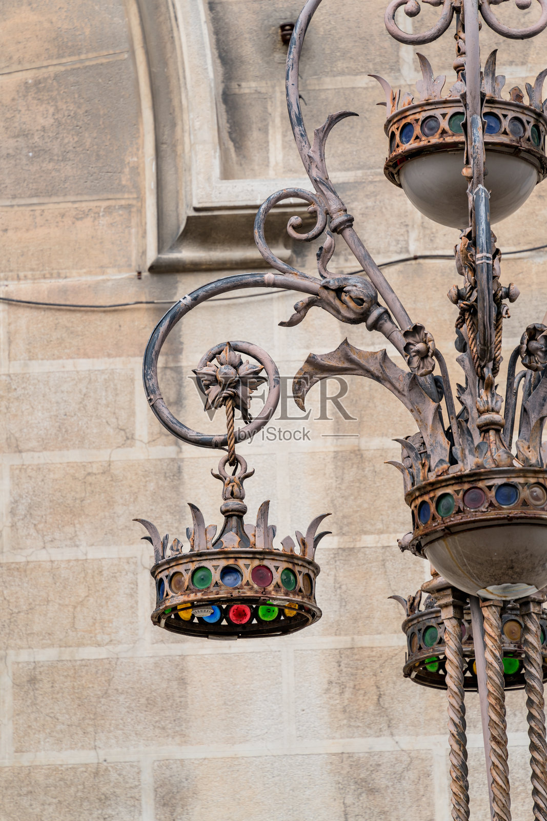 一盏顶部有王冠的金属灯，发出绿色光芒，位于意大利翁布里亚的佩鲁贾。照片摄影图片