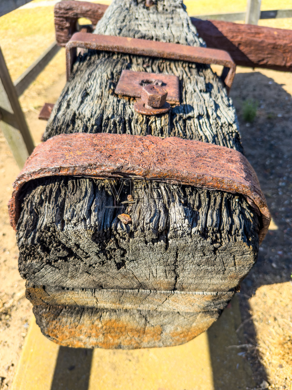 一块生锈的铁片绑在一根非常风化的木梁上照片摄影图片