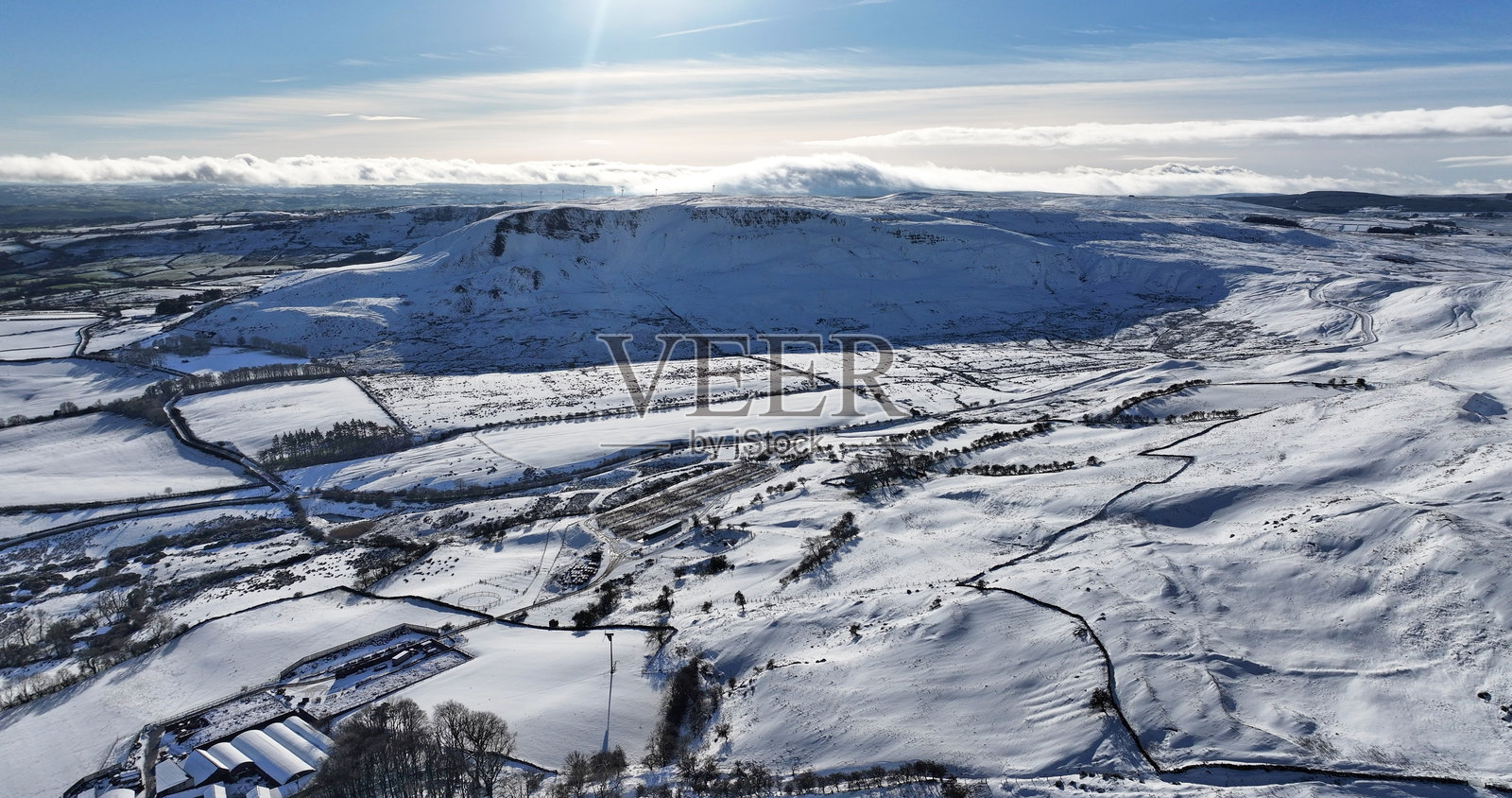 从空中俯瞰安特里姆郡卡恩卡斯尔的雪覆盖诺克杜山上方的融化雾气照片摄影图片