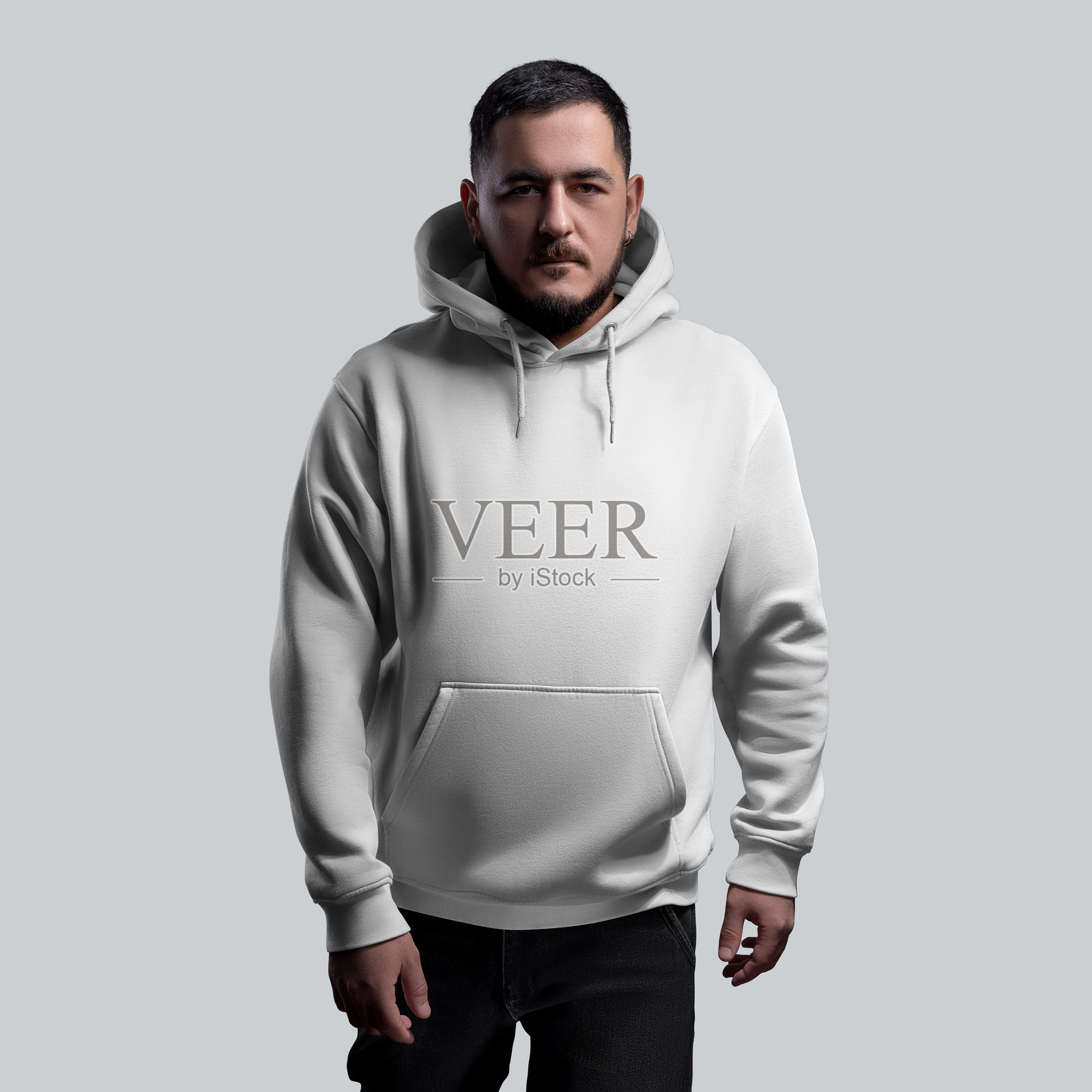 白色宽松连帽衫模特，搭配黑色牛仔裤，正面视图，背景为单色。照片摄影图片