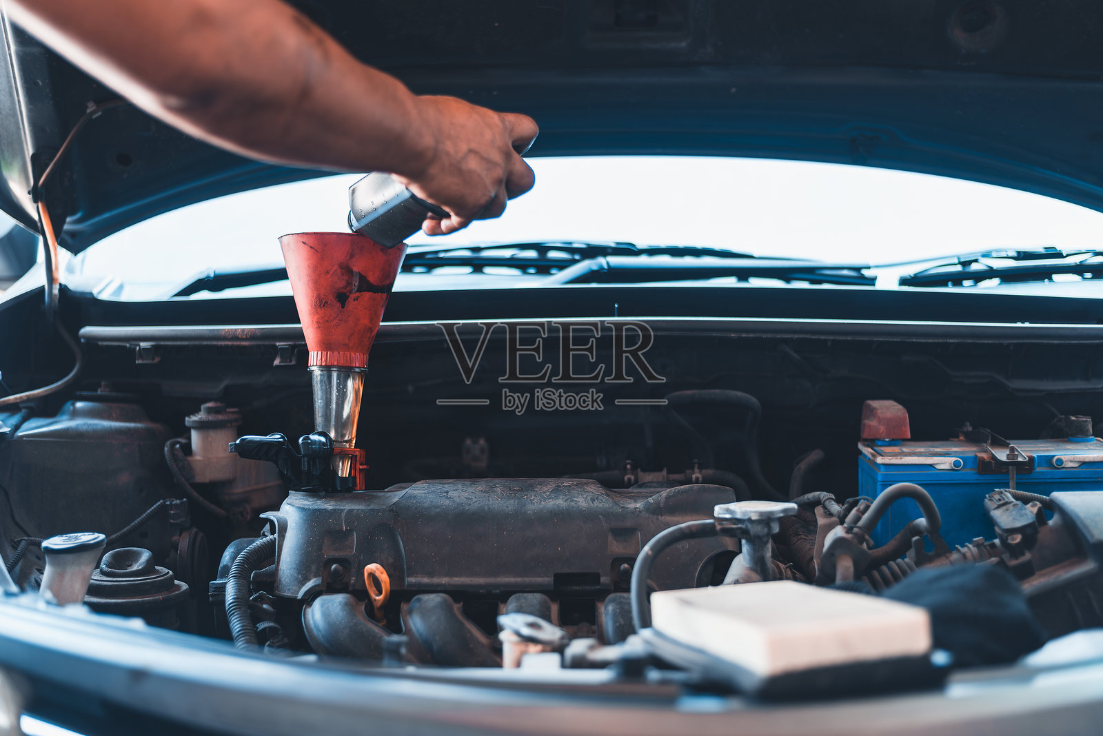 给汽车发动机添加机油的人照片摄影图片
