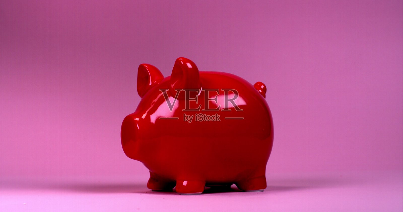 一把锤子砸碎了储蓄罐，碎片和硬币四散飞舞。照片摄影图片