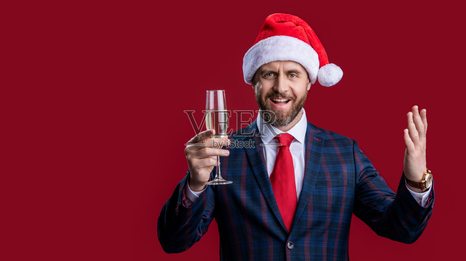 微笑的新年商人戴着圣诞老人帽子庆祝节日。照片摄影图片