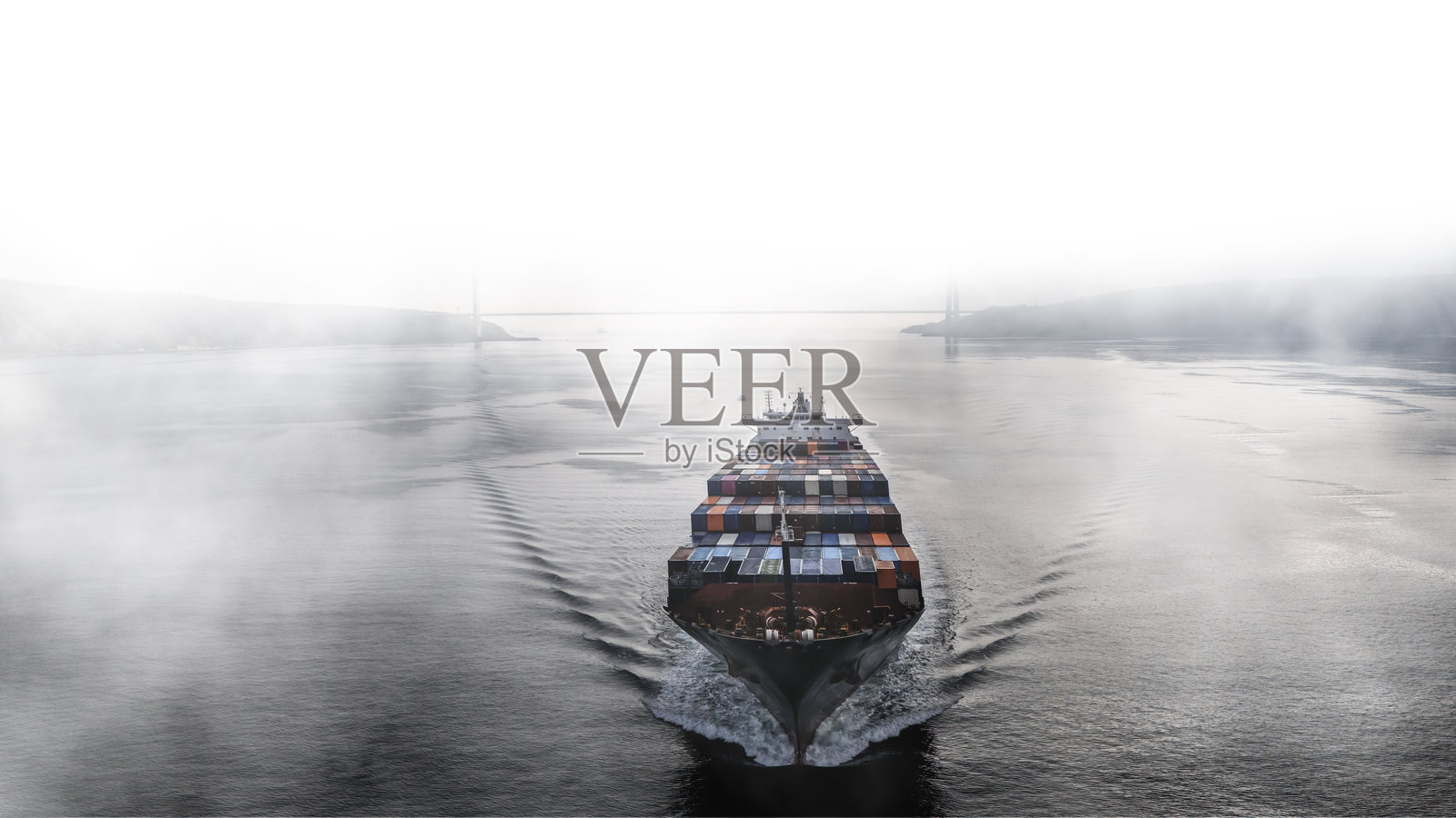 雾天航行中的货船鸟瞰图。照片摄影图片