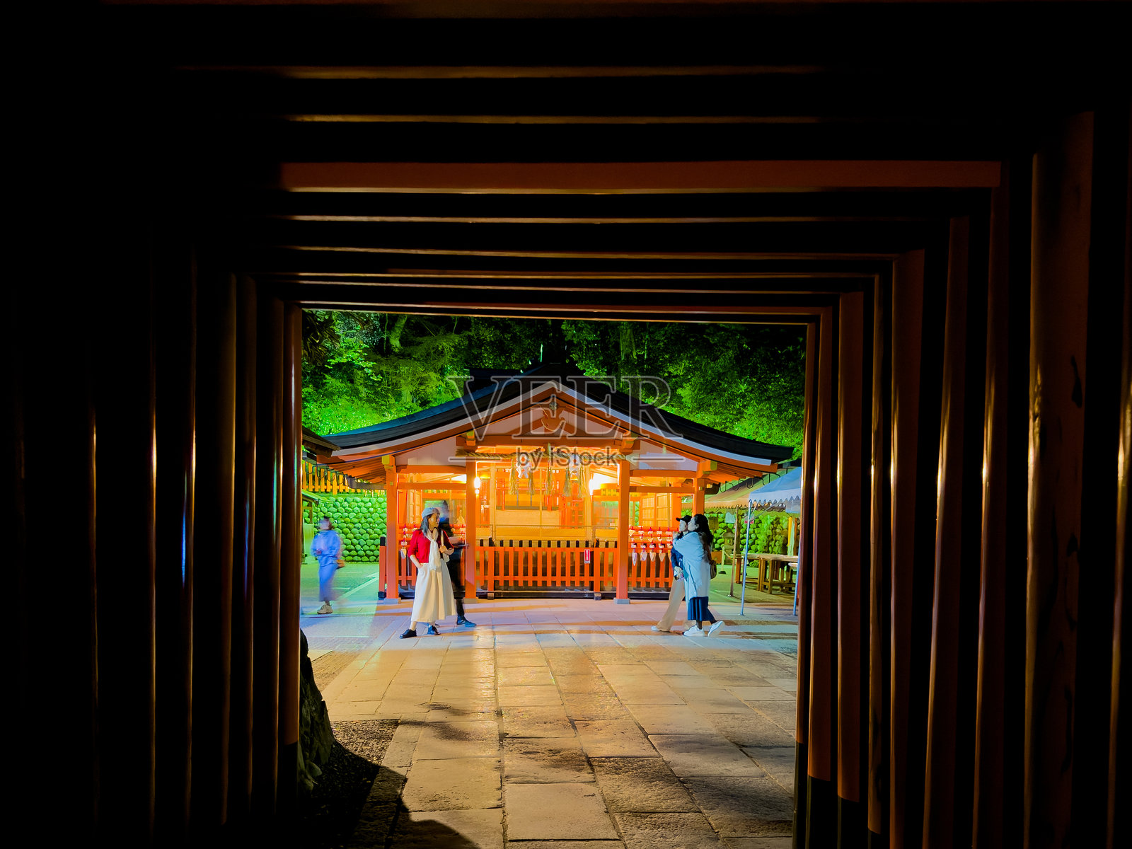 日本。伏见稻荷大社。京都。夜晚的神社被鸟居隧道框住。照片摄影图片