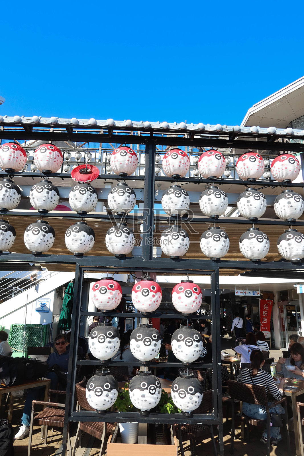 黑色、红色和白色的圆形纸制河豚灯笼悬挂在海鲜市场的架子上照片摄影图片