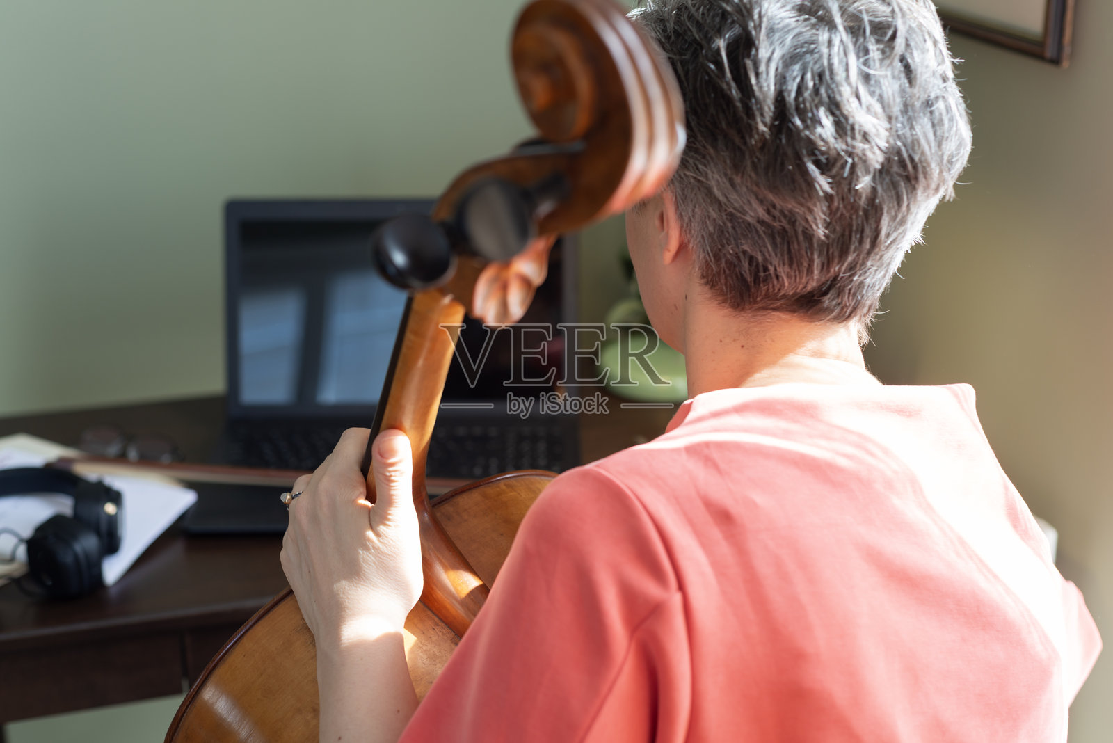女人在笔记本电脑上观看大提琴演奏教程照片摄影图片