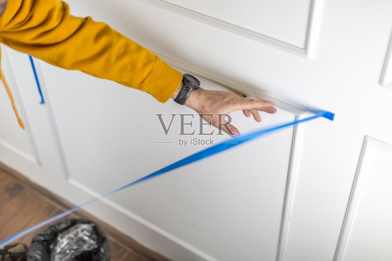 胶带被精确地贴上，以避免油漆渗透到装饰条上。照片摄影图片