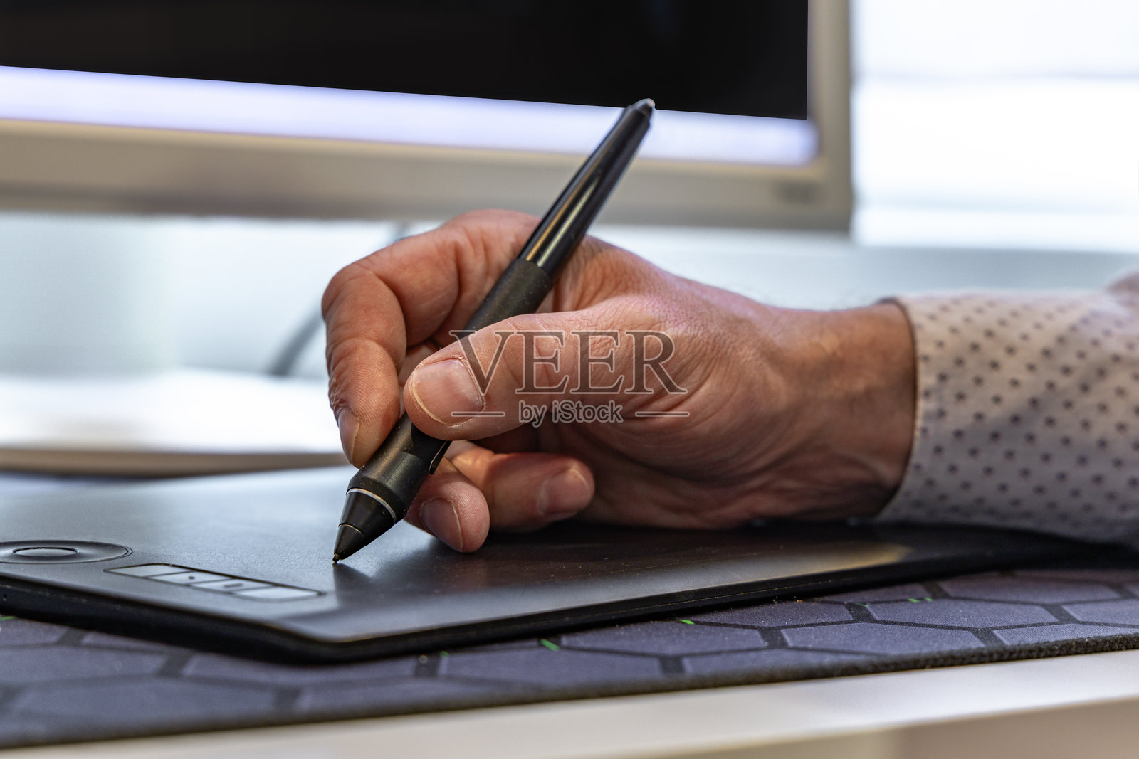 男子使用电子笔在数字平板上绘画照片摄影图片