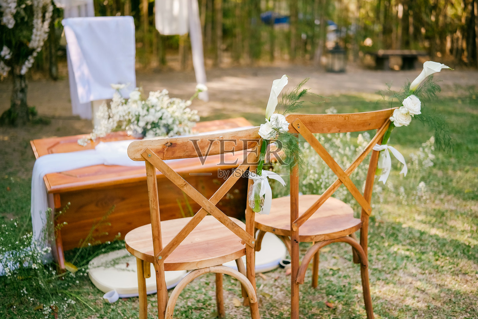 乡村户外婚礼仪式布置，配有木椅和自然花卉装饰，位于自然花园环境中照片摄影图片