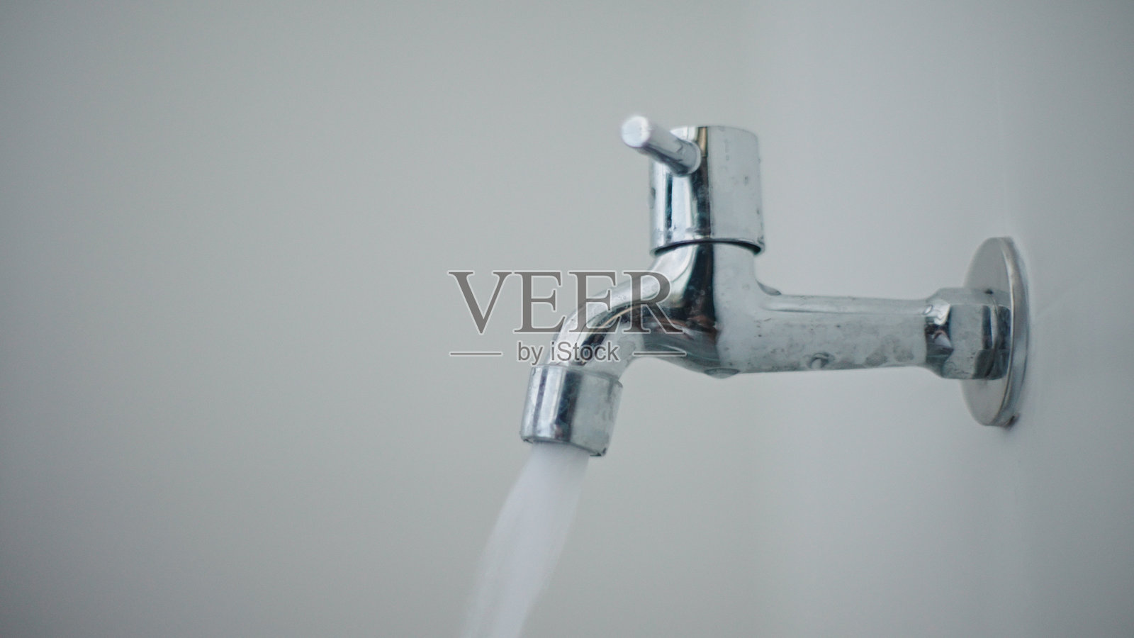 在浴室打开或关闭水龙头。照片摄影图片