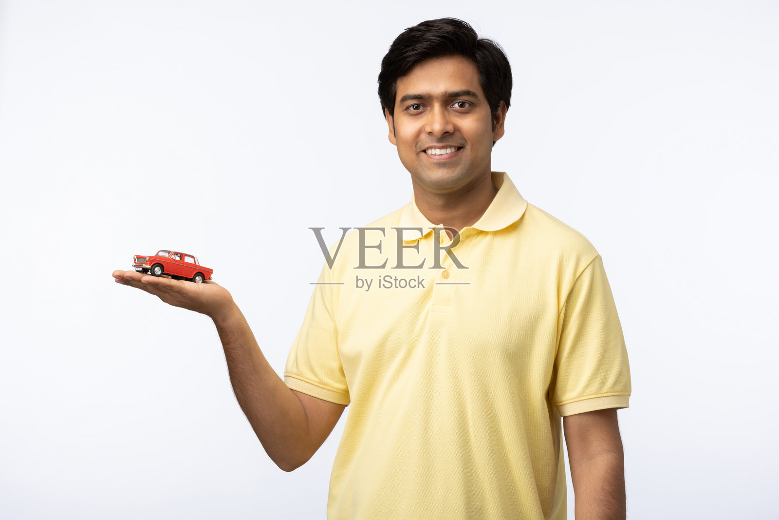 年轻男子展示汽车贷款，背景为白色照片摄影图片