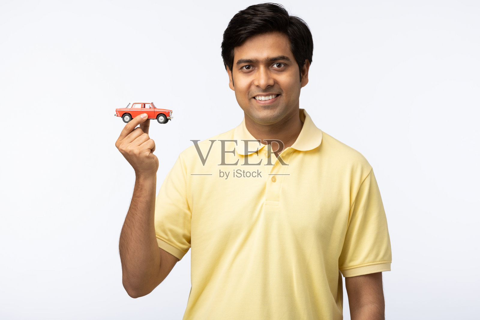 年轻男子展示汽车贷款，背景为白色照片摄影图片