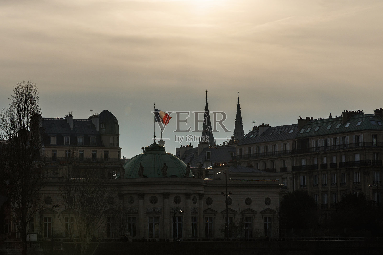法国国旗在一座顶部有圆顶的建筑上飘扬照片摄影图片