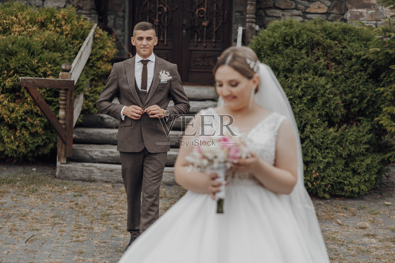 一对新郎新娘站在教堂门前照片摄影图片