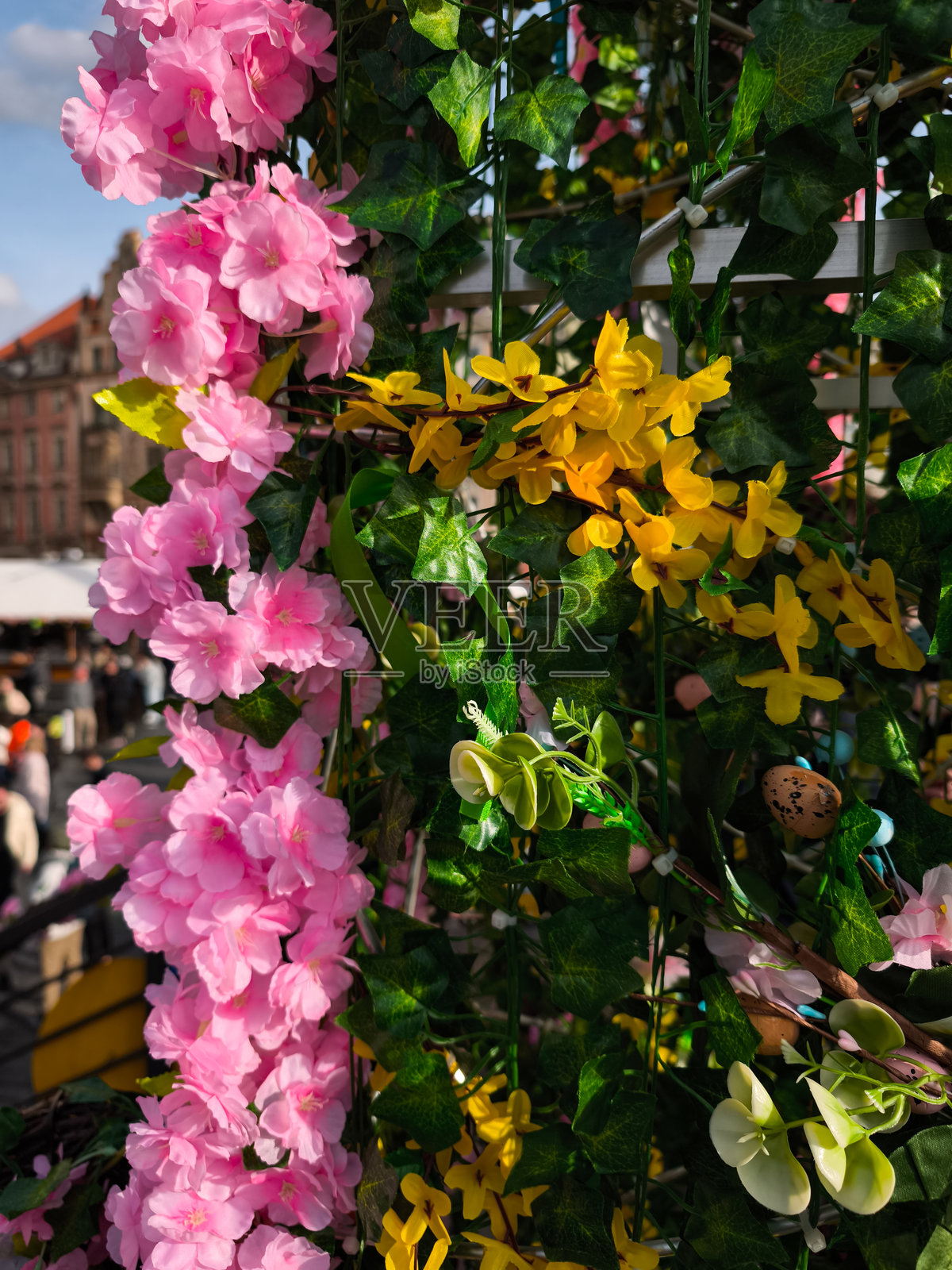 粉色和黄色的人工花装饰着布拉格老城广场的复活节市场照片摄影图片