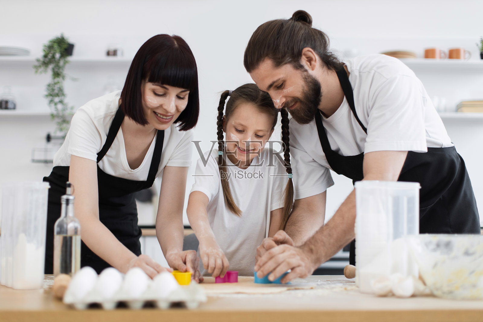 高加索家庭在明亮现代的厨房里一起烘焙饼干照片摄影图片
