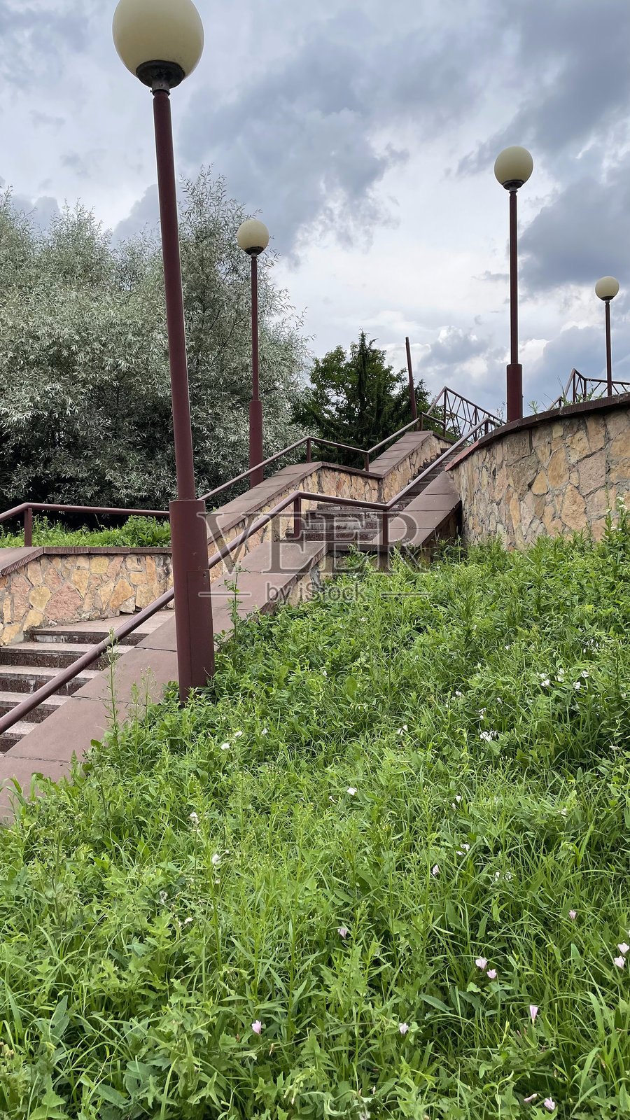 公园里的台阶，前景是绿色的草坪和花朵照片摄影图片