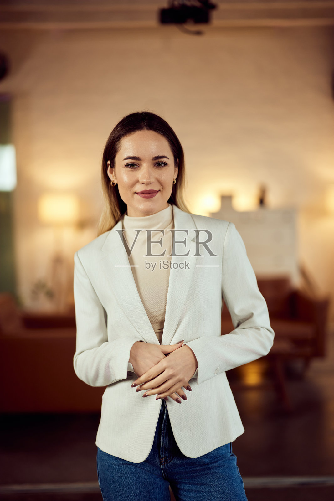 自信的女性穿着时尚服装，站在舒适的室内环境中照片摄影图片