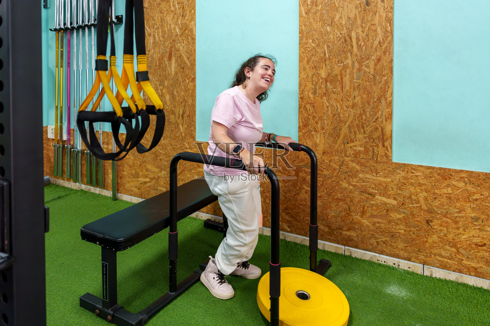 年轻女性在健身房锻炼，患有脑性瘫痪照片摄影图片