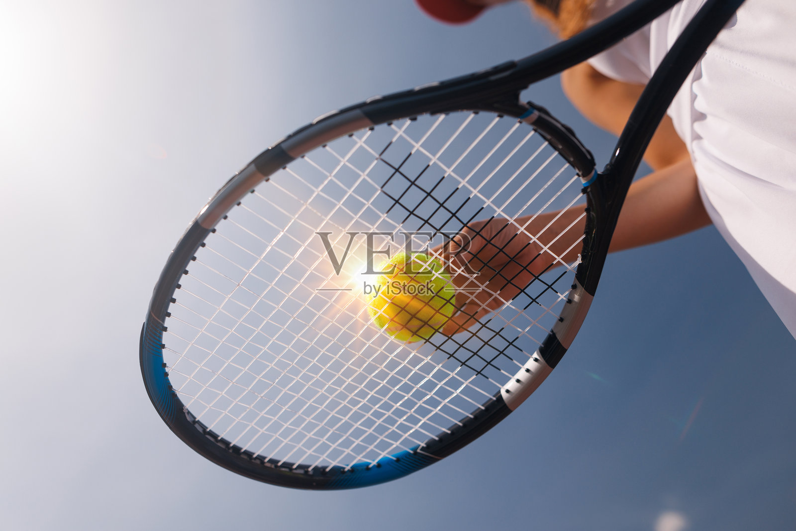 年轻的网球运动员在打网球，底部视角照片摄影图片