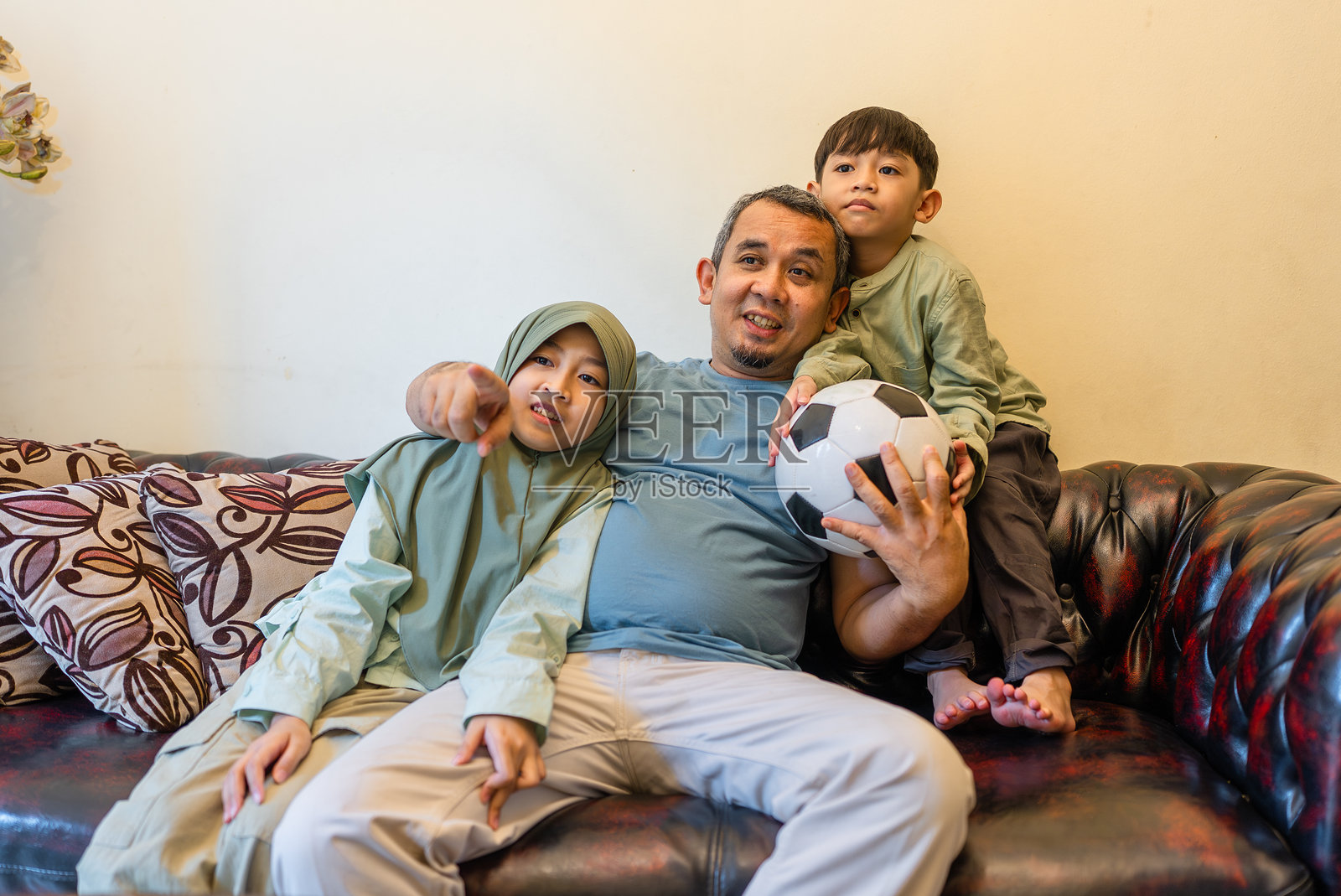 父亲和孩子们在看电视体育比赛照片摄影图片