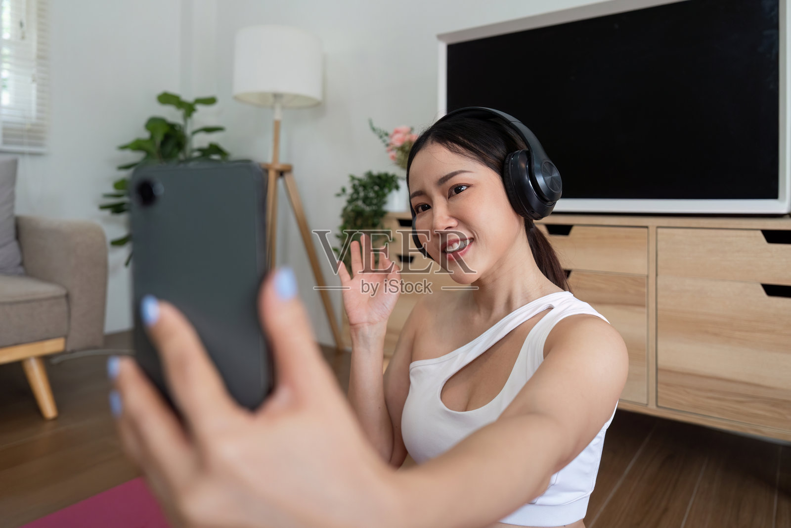 瑜伽与连接。一位女性在家中练习瑜伽时自拍，散发出自信和积极的气息。照片摄影图片