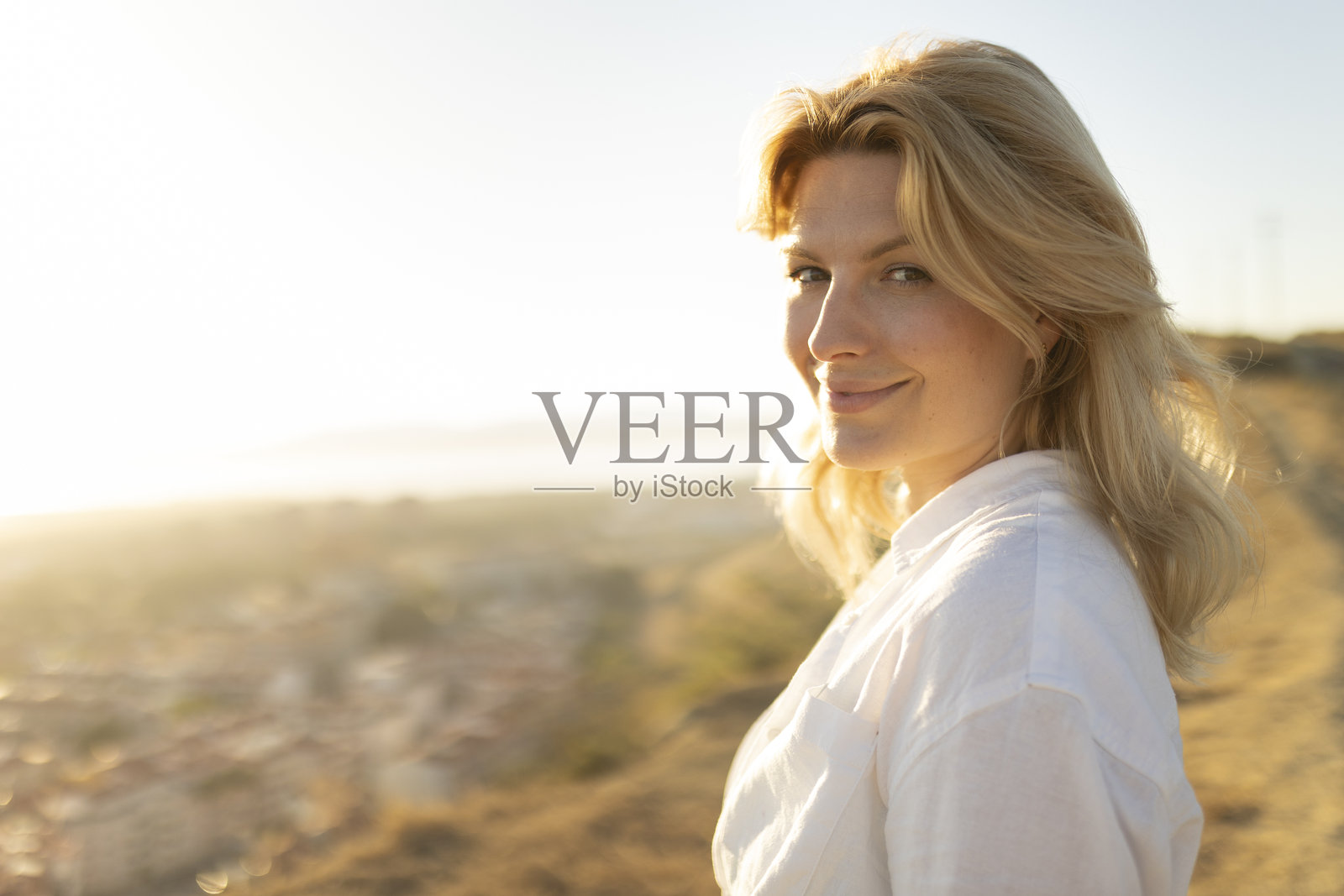 金发女性在风景优美的观景台享受金色时光的光线照片摄影图片