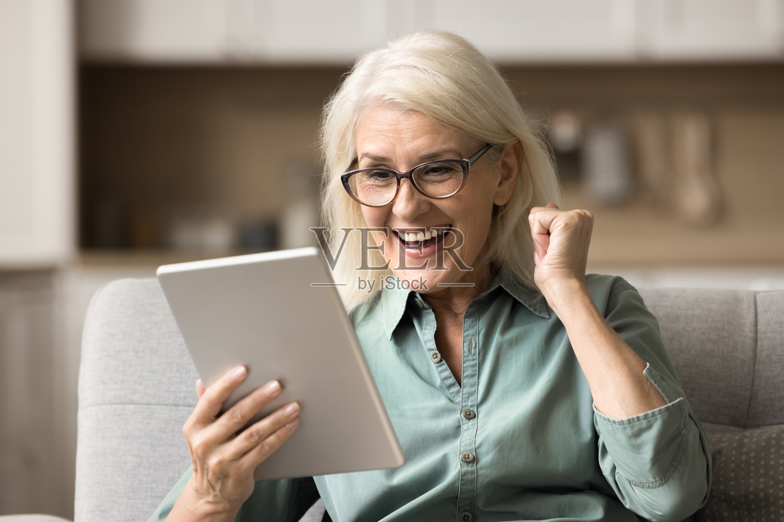 女人手持平板，收到令人兴奋的消息，感到非常开心照片摄影图片