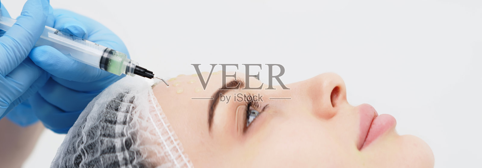 美容师为年轻女性进行面部去角质的特写。专业护理、焕肤和健康肌肤的概念。照片摄影图片