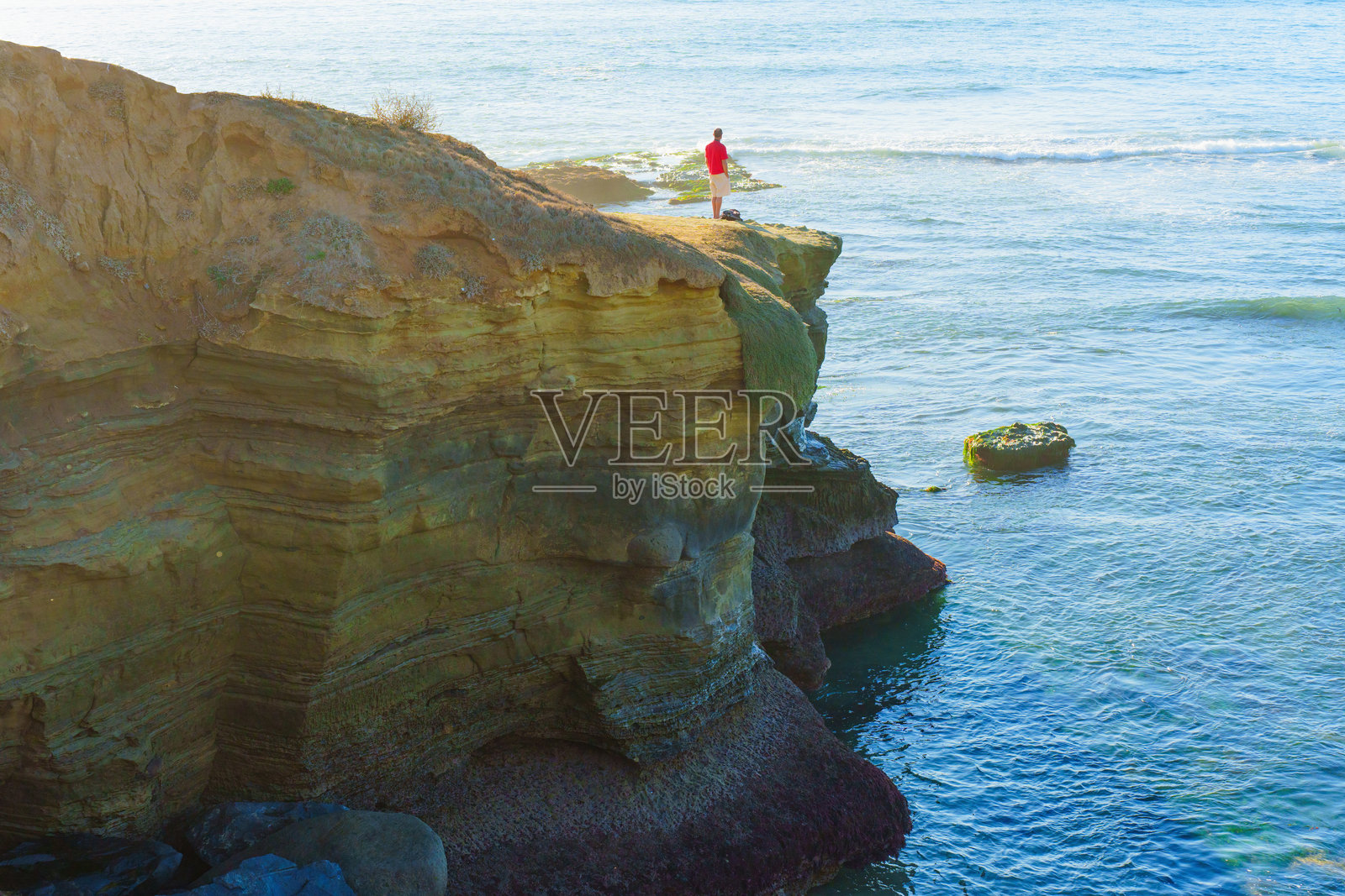 在加利福尼亚州圣地亚哥的悬崖上欣赏壮丽海洋景色的人照片摄影图片