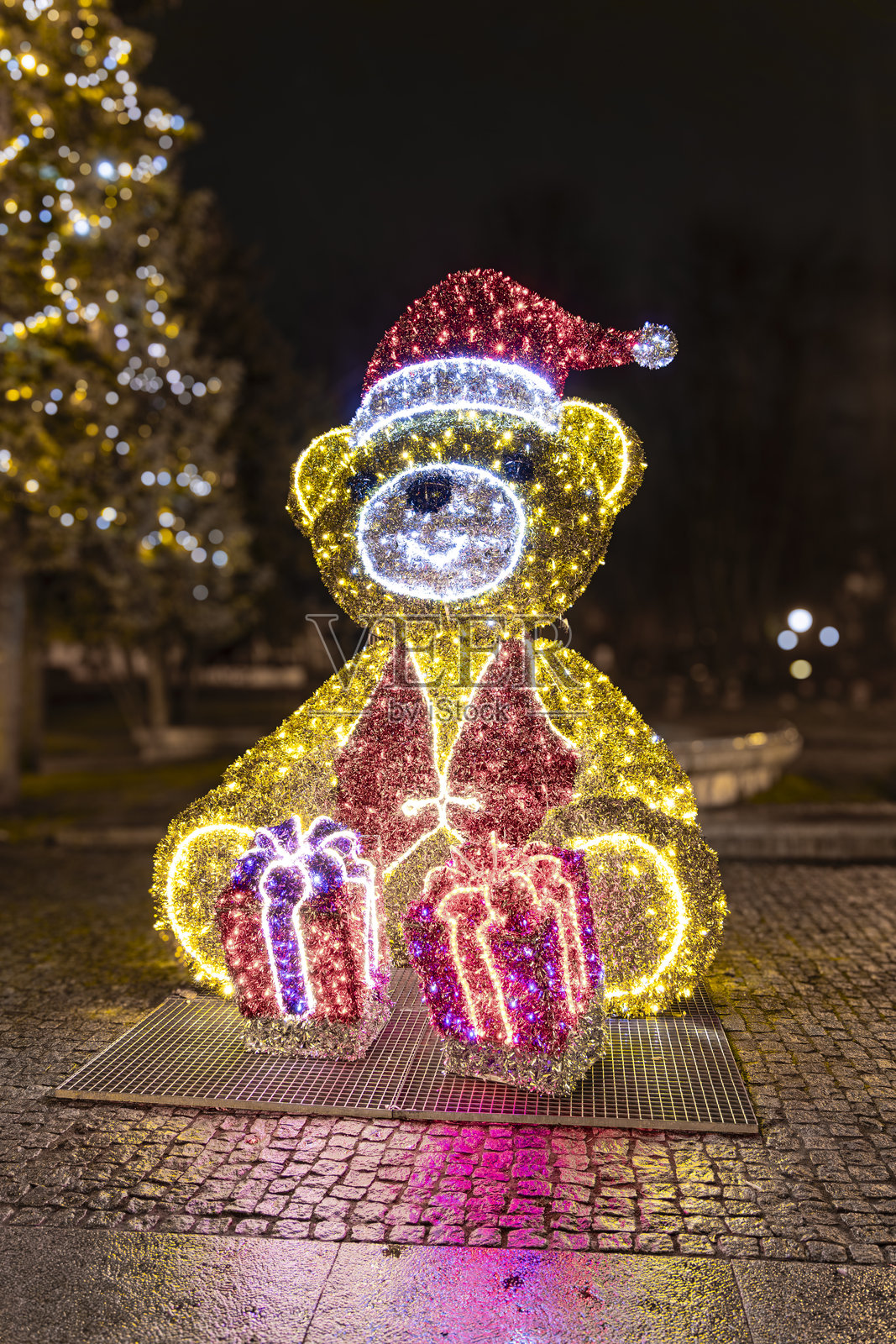 城市公园夜间的照明圣诞熊装饰与礼物，节日灯光展示照片摄影图片