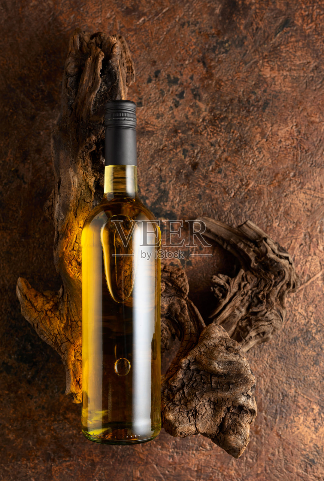 一瓶白葡萄酒和古老的风化木头在棕色复古背景上。照片摄影图片