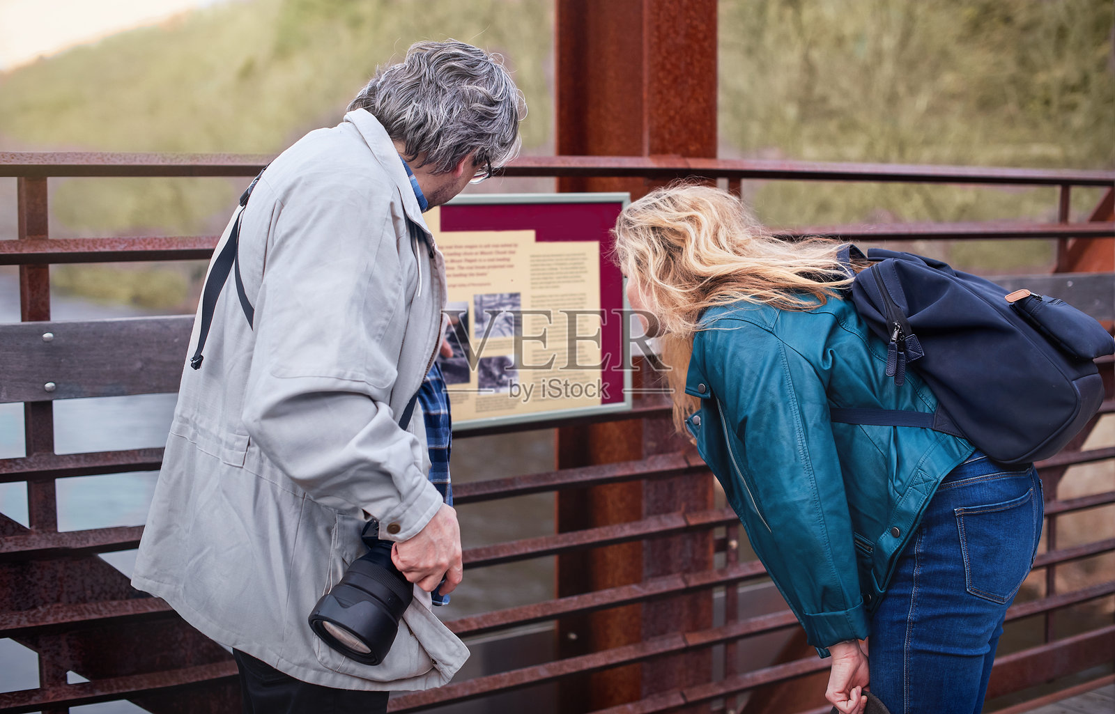 游客在阅读信息牌。成熟的夫妇在宾夕法尼亚州的波科诺山探索自然小径。照片摄影图片