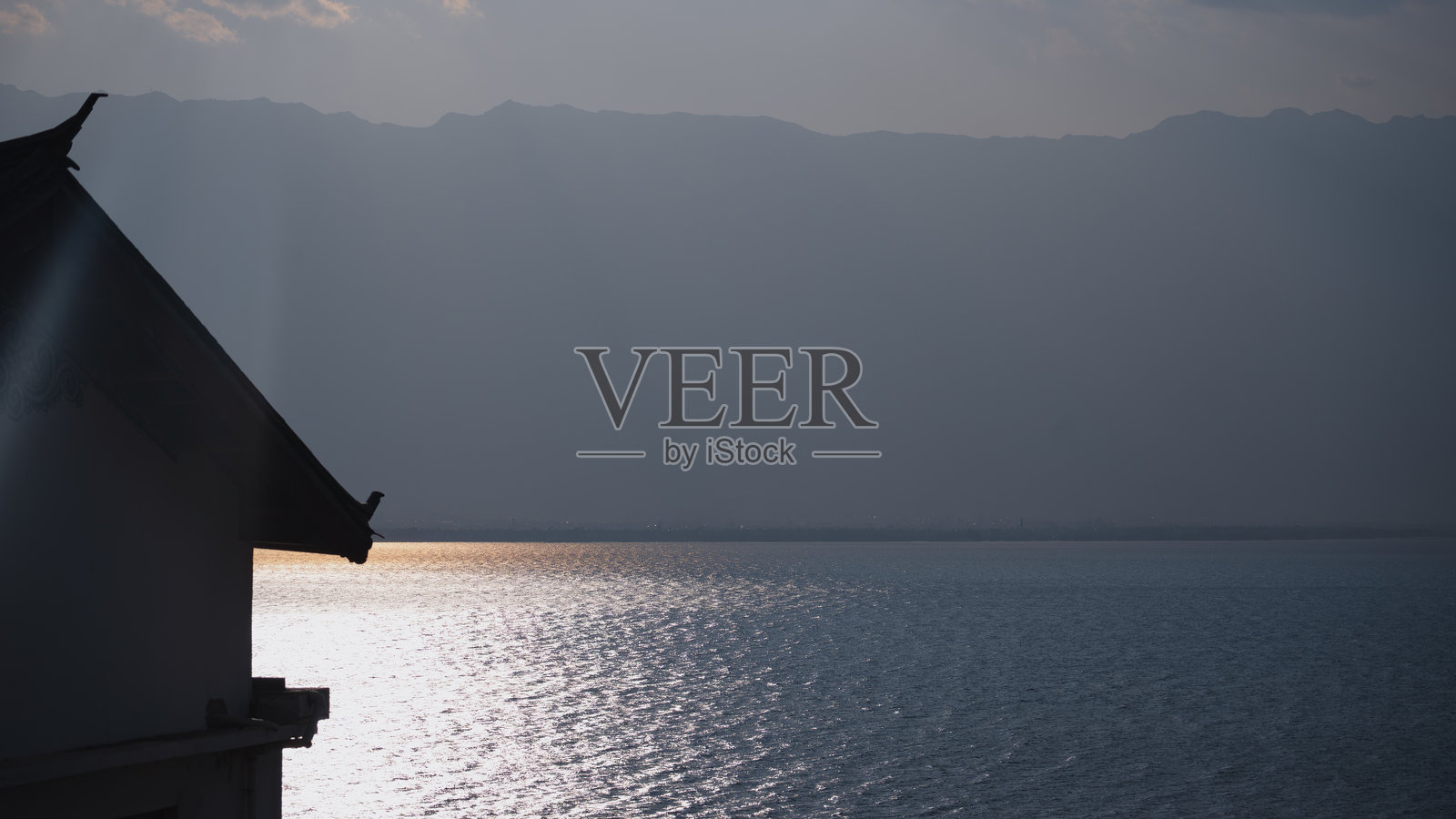 阳光洒在洱海旁的传统屋檐上照片摄影图片