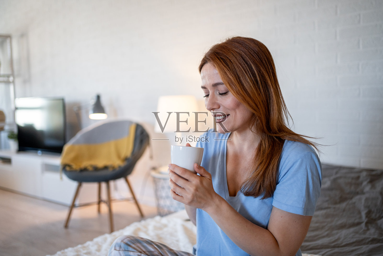 宁静的女性在床上享受早晨咖啡：以放松的方式开始新的一天照片摄影图片