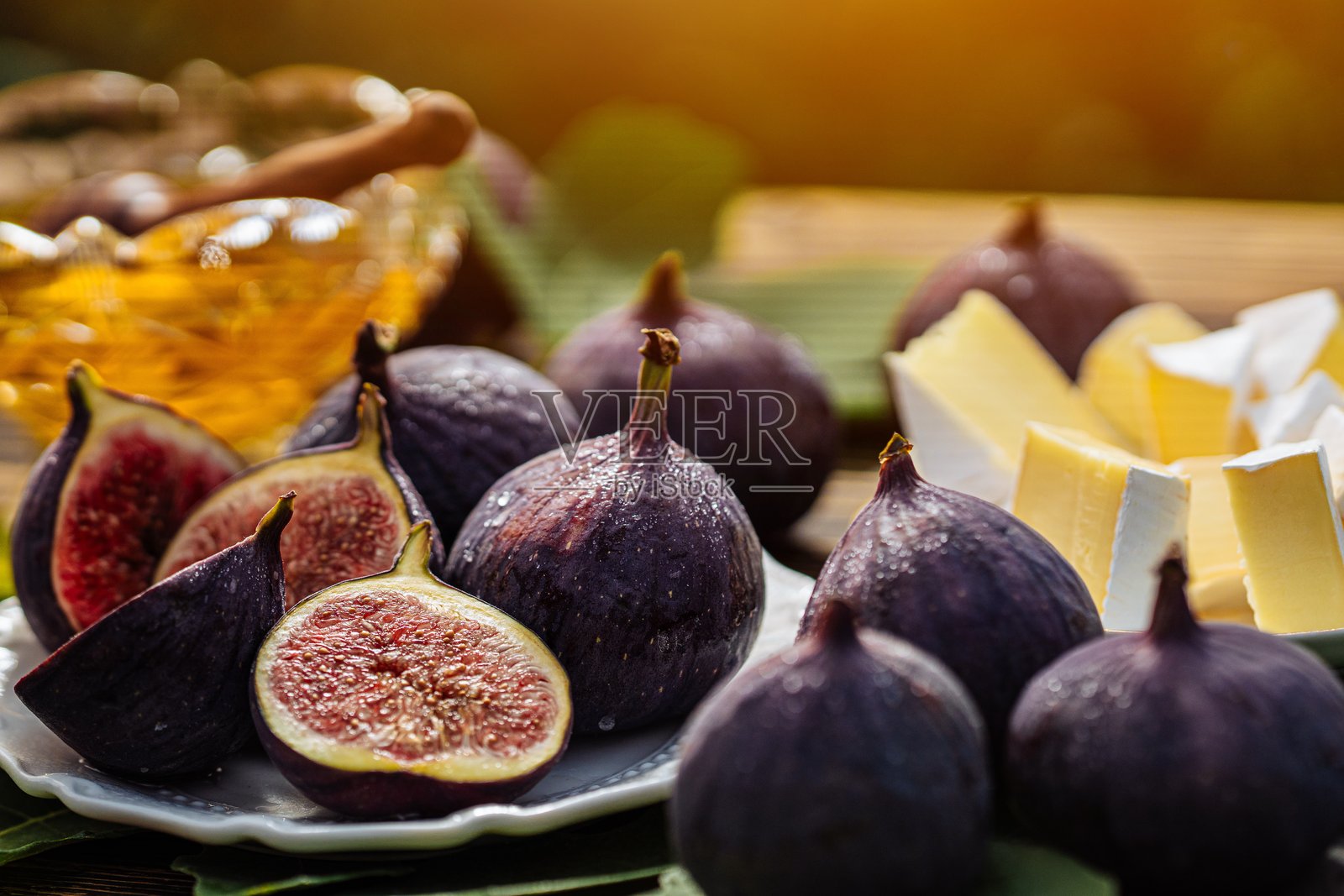 奶酪拼盘，配有卡门贝尔奶酪、布里奶酪、健康多汁的有机无花果、蜂蜜和葡萄照片摄影图片