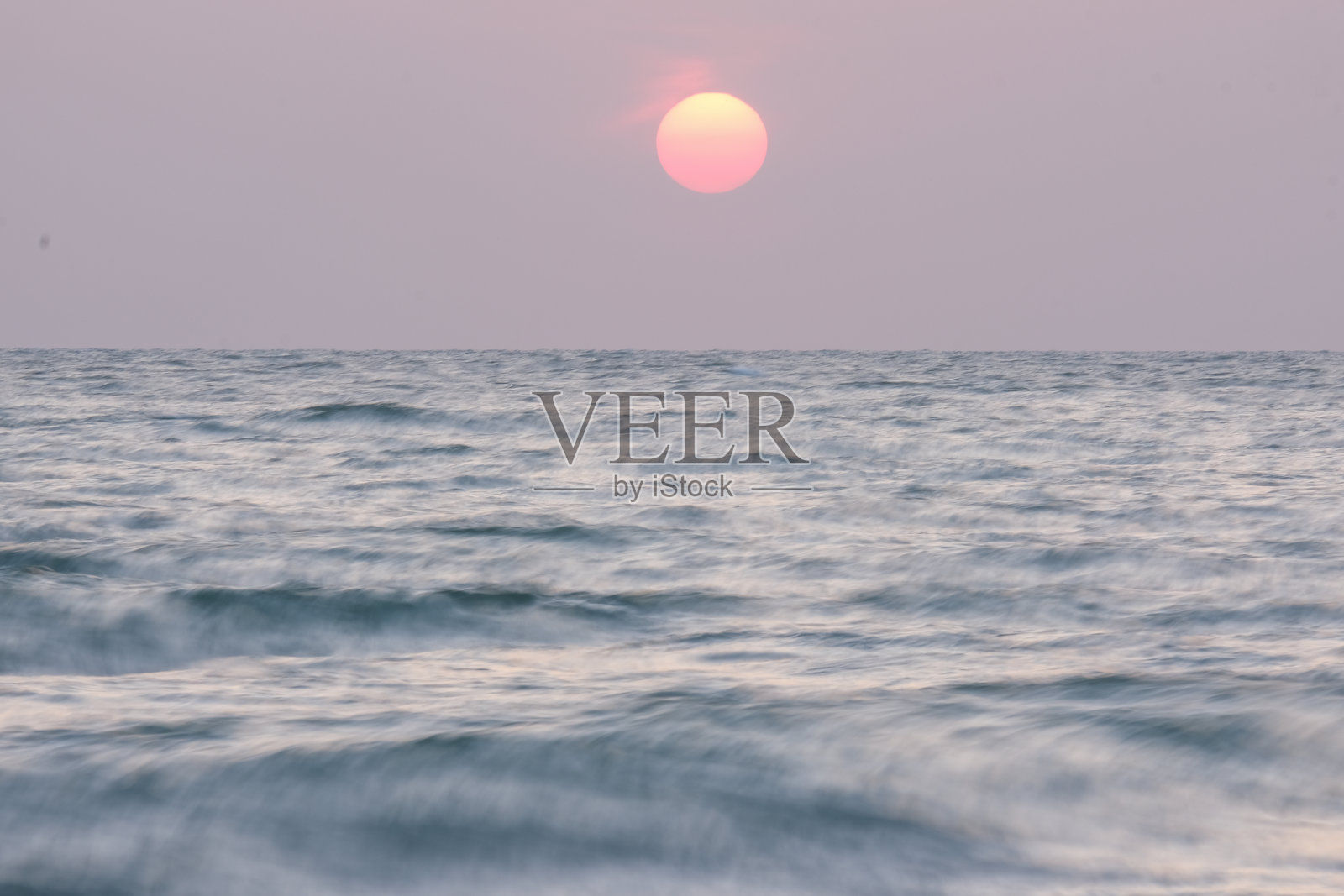 海浪与黎明的天空形成鲜明对比。照片摄影图片