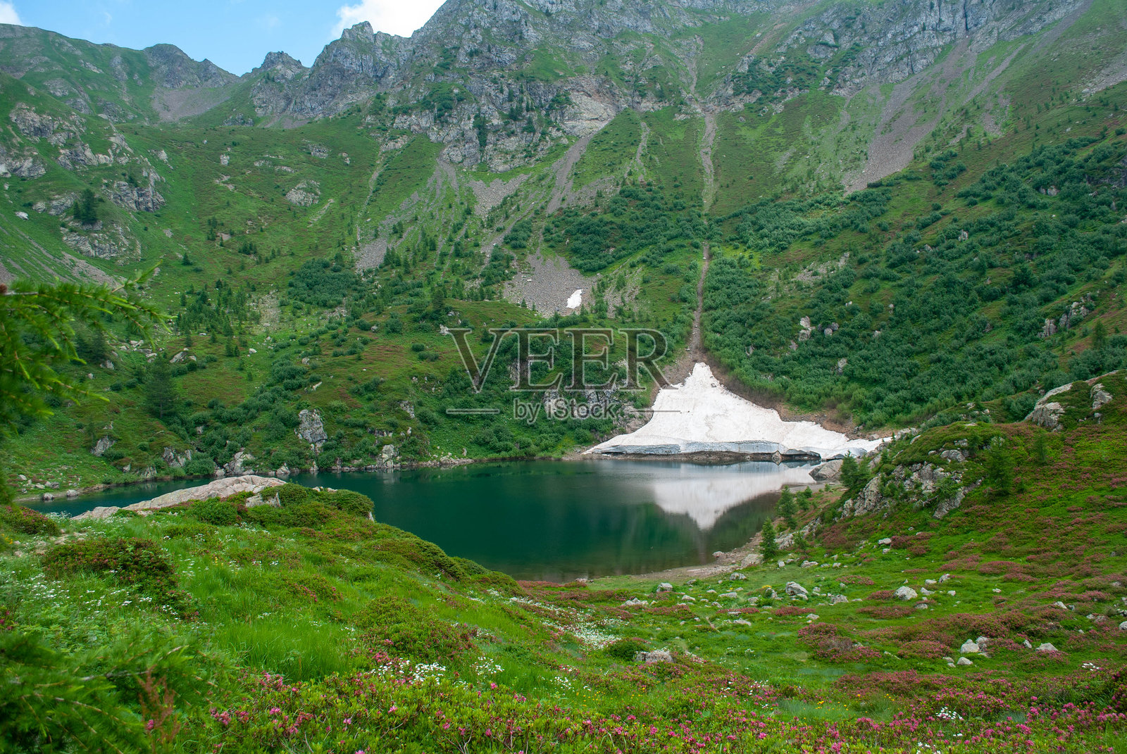 意大利阿尔卑斯山夏季湖边融化的雪照片摄影图片